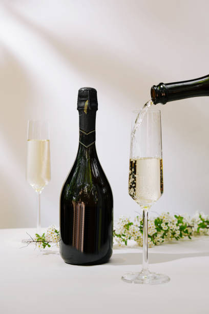 istock Sparkling wine being poured into a glass with floral decorations in a festive setting 2197929406