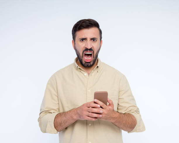 istock Portrait of angry man using smart phone 2197930136