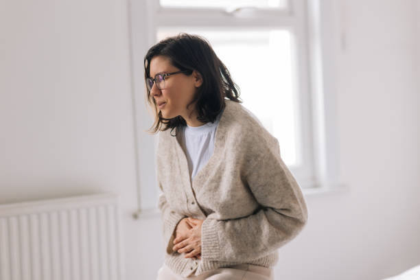 istock Young woman with stomach ache 2197930358