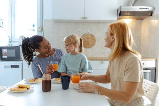 istock Same sex family enjoying breakfast together in modern kitchen setting 2197931007