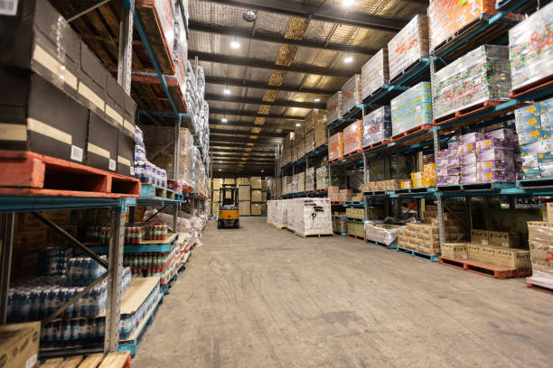 istock Large Warehouse Filled with Pallets of Stacked Goods and Forklift in View 2197932012