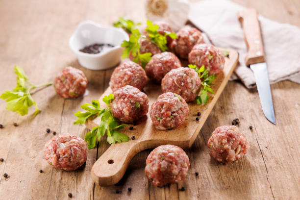istock raw meatball with herb on wooden board 2197933147