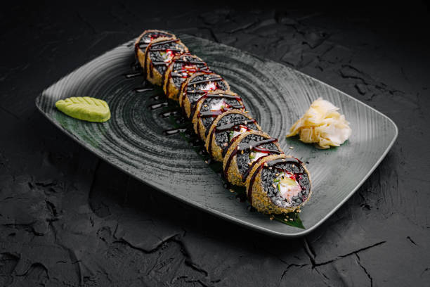 istock Delicious sushi roll plated beautifully on a dark textured surface with wasabi and pickled ginger 2197933173