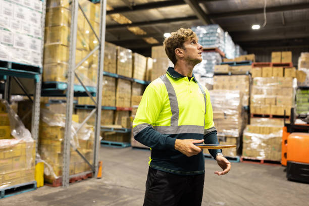istock Warehouse Worker Inspecting Inventory with a Clipboard in an Organized Storage Facility 2197933286