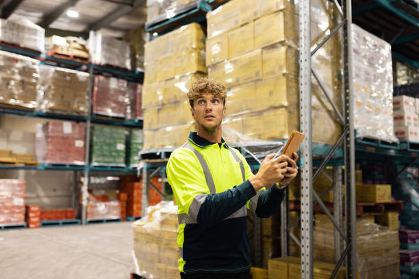 istock Warehouse Worker Managing Inventory With Device in Industrial Storage Facility 2197933504