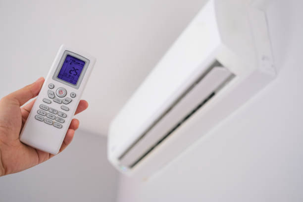 istock Man's hand using remote control open The air conditioner is cooled to 25 degrees Celsius in his bedroom. Health concepts and energy savings 2197934154
