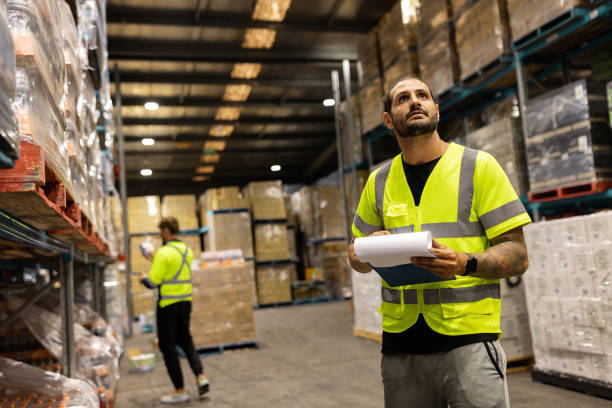 istock Warehouse Workers Checking Inventory on Rows of Shelves 2197934853