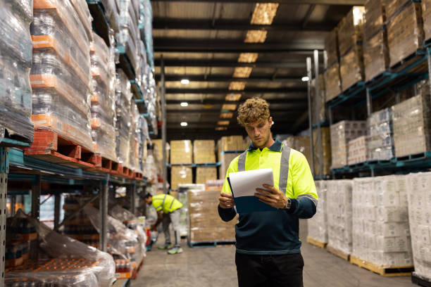 istock Warehouse Worker Reviewing Inventory Documents in Modern Distribution Center 2197935287