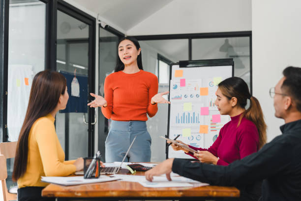 istock woman presenting ideas to team in modern office 2197936537