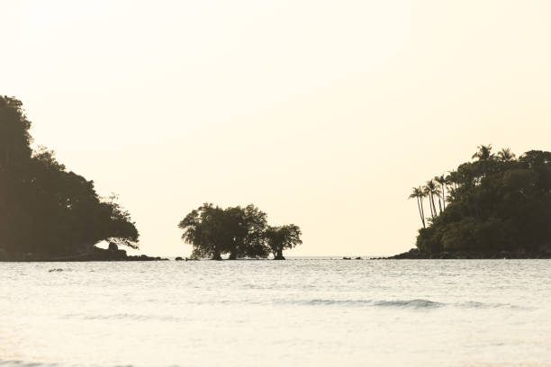 Little tropic island is on middle of the ocean with sunrise sky background.Phuket Island - Thailand.