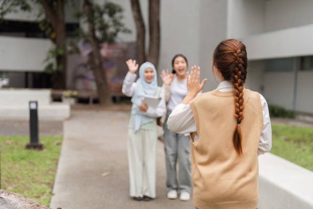 istock Diverse university students waving to a friend, showcasing camaraderie on campus. 2197941758