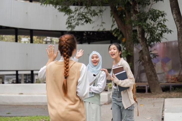 istock Diverse multicultural women greeting friend outdoors on campus with excitement. 2197941822
