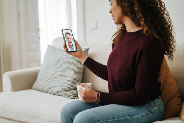 istock Woman using phone talk to doctor sitting on sofa 2197941839