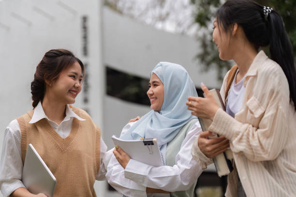 istock Diverse young women friends enjoying time together, sharing study materials. 2197942048