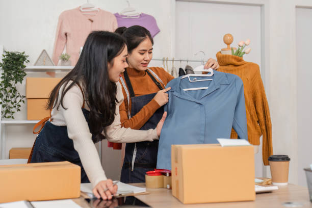 istock Diverse female e-commerce employees discussing clothing styles in retail store. 2197942722