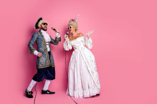 istock Elegant couples showcasing vintage costumes singing joyfully on a pink background 2197943185