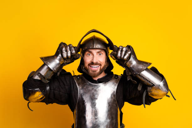 istock Happy knight in metallic armor poses on a vibrant yellow background in a cheerful expression 2197943352