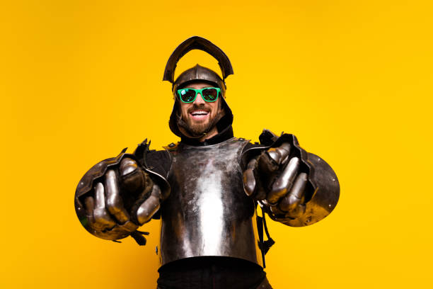 istock Young man in knight armor with sunglasses posing against bold yellow background 2197943442