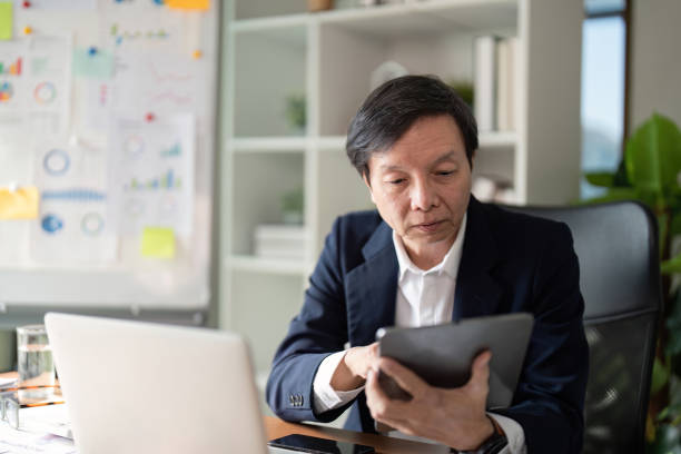 istock Elderly businessman engaged in work modern office portrait professional environment focused perspective 2197943694