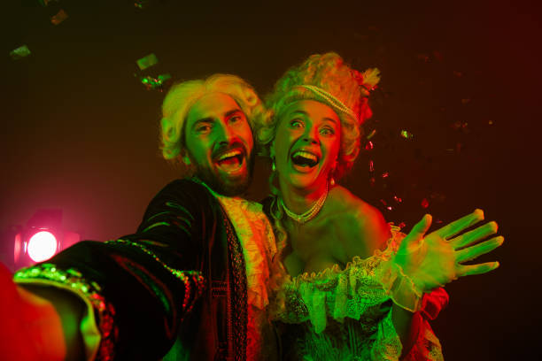 istock Cheerful costumed couple at a glamorous party with dramatic lighting 2197943723