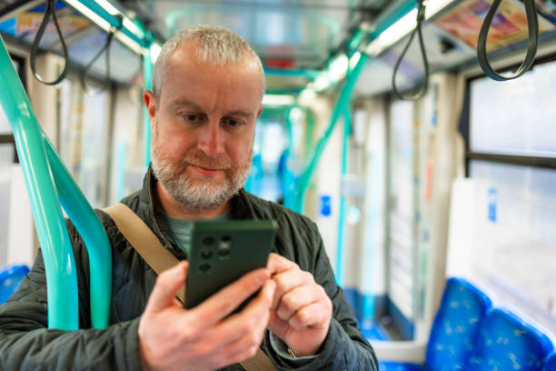 istock Mid adult man using smart phone on commuter train in city 2197945176