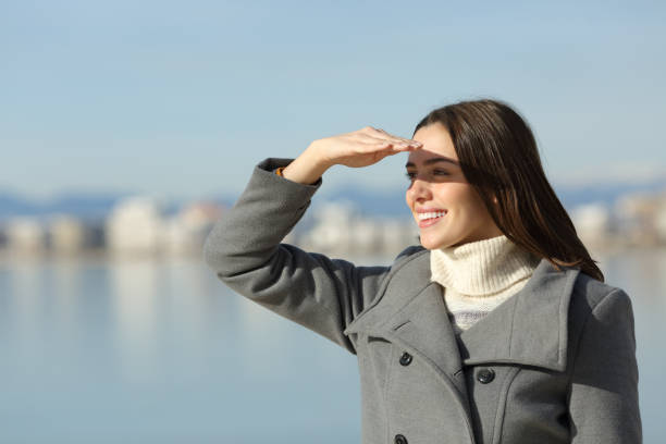 istock Happy woman in winter protecting from sun with hand 2197945241