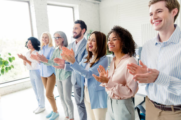 istock Group of diverse business professionals applauding in a modern office environment with daylight 2197946201