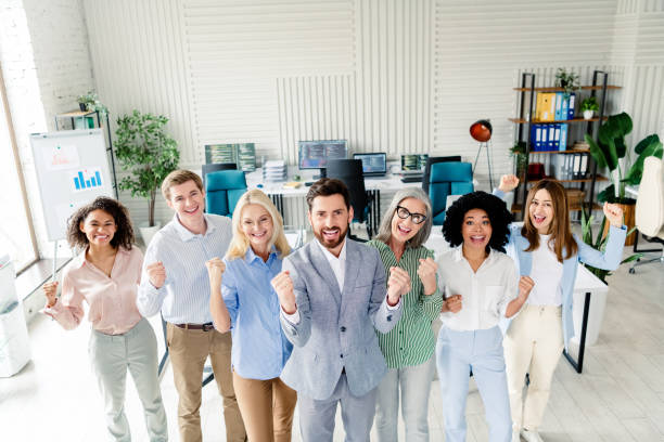 istock Group of diverse happy business professionals cheering at work in bright modern office environment 2197946212