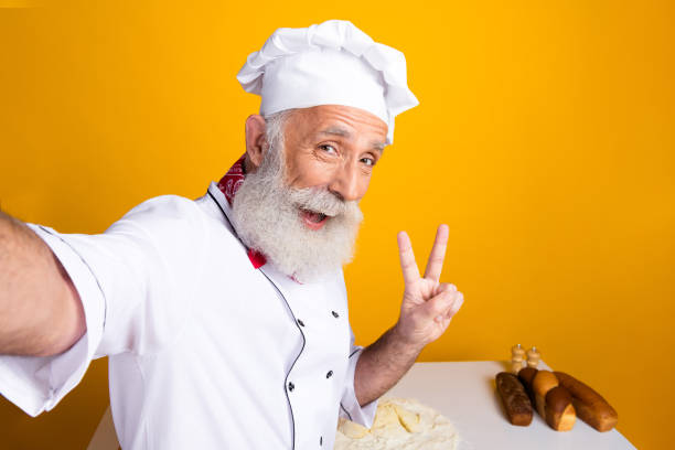 istock Cheerful Senior Chef Posing in Professional Uniform in Bright Kitchen Setting 2197953864