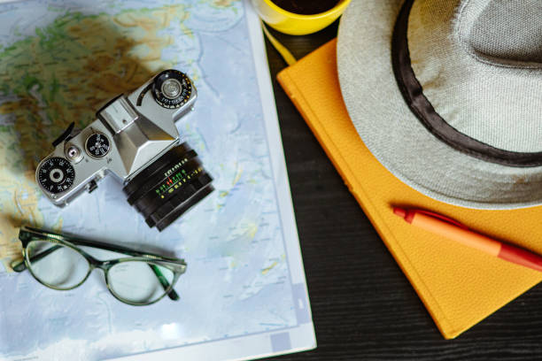 Trekking boots for hiking next to a world globe model on a white background. Equipment for travel and hiking