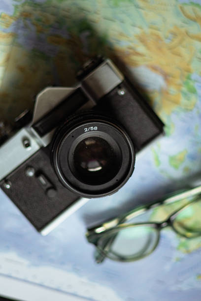 istock Travel planning. Vintage film camera and world map on rustic black table. 2197954180