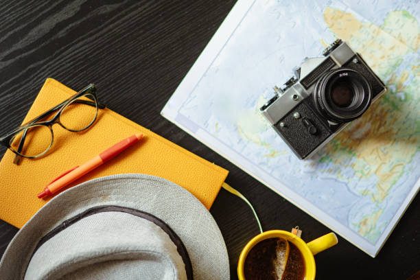 istock Travel planning. Vintage film camera, world map and straw hat on rustic black table. 2197954321