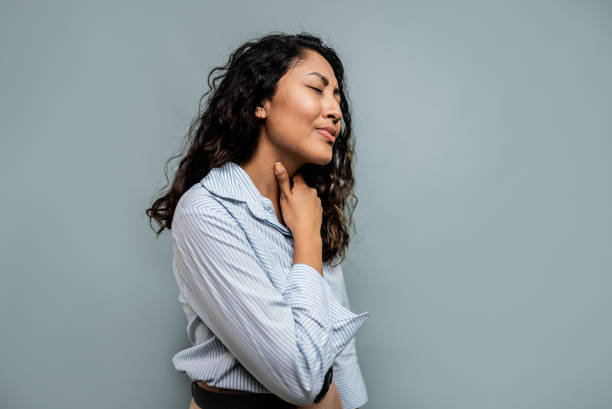 istock Young woman with sore throat on a gray background 2197954364