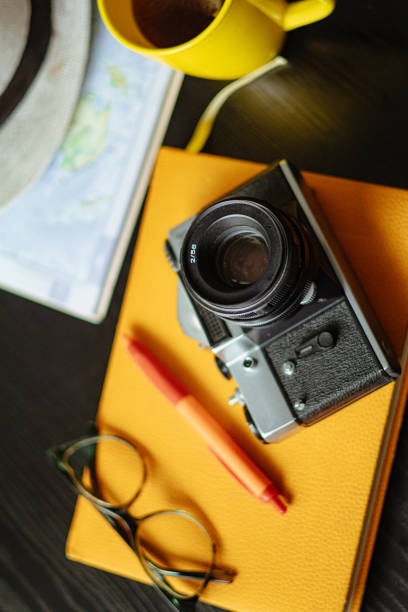 istock Travel planning. Vintage film camera, world map and straw hat on rustic black table. 2197954705