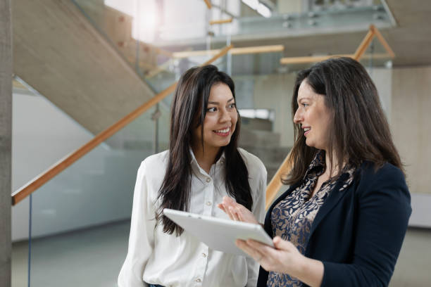 istock Businesswomen using digital tablet in lobby. 2197956093