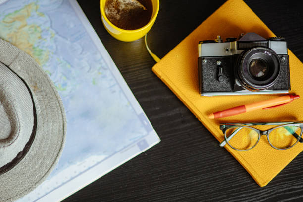 istock Travel planning. Vintage film camera, world map and straw hat on rustic black table. 2197956736