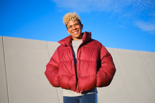 Happy young woman looking at the camera and enjoying outdoor activity stock photo