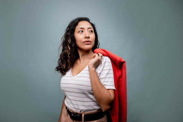 istock Young woman carrying coat on a gray background 2197964613