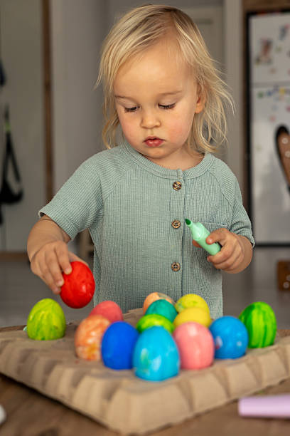 istock Colorful Easter egg decorating activity at home during spring holiday with a child 2197964663
