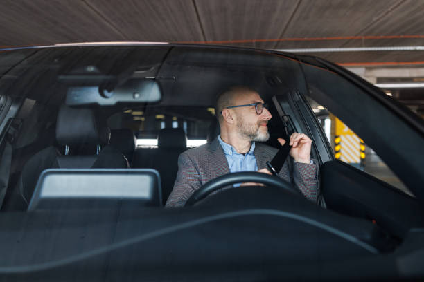 istock A smiling man putting on his seat belt. Driving safe. 2197965561