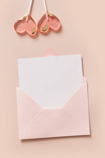 istock Valentine's day greeting card with blank, envelope and two pink lollipops sweets on pink 2197972279