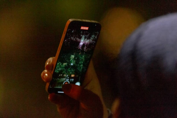 istock Person Holding Smartphone Capturing Night Sky in Dark Background 2197975216