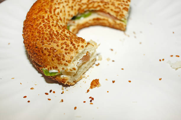 Bagel with salat and salmon. Turkish simit on the white plate. Menu concept. Close up. High quality photo