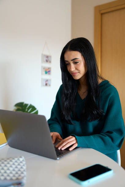 istock Young woman working on laptop at home 2197977307