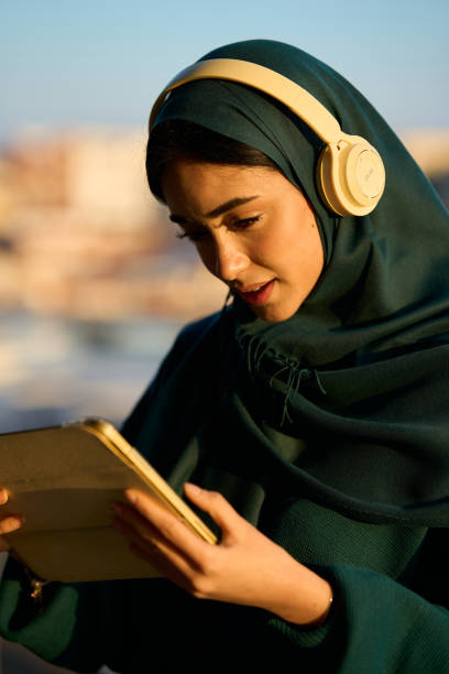 istock Young woman engaging with digital tablet outdoors 2197977704