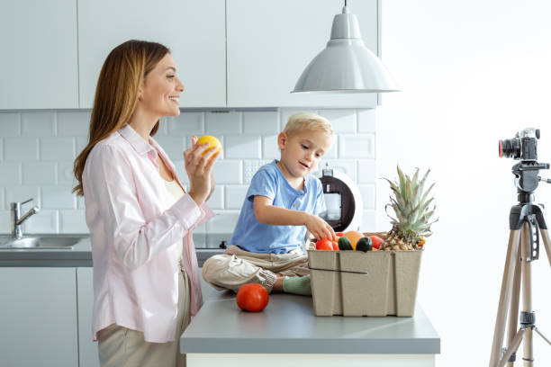 istock Woman and child recording a healthy eating tutorial in a modern kitchen 2197981100