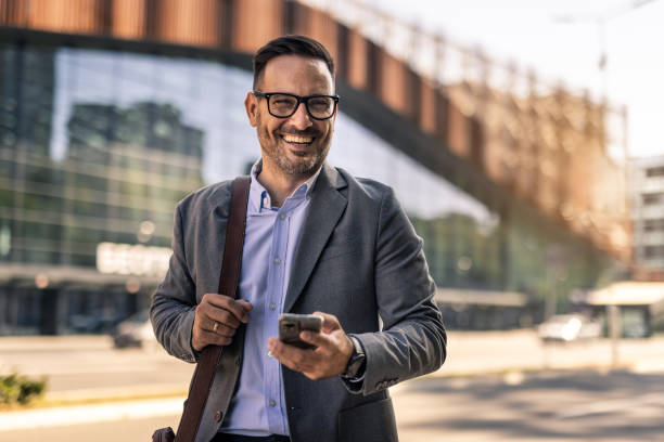 istock Businessman walking in the city, using phone 2197982634