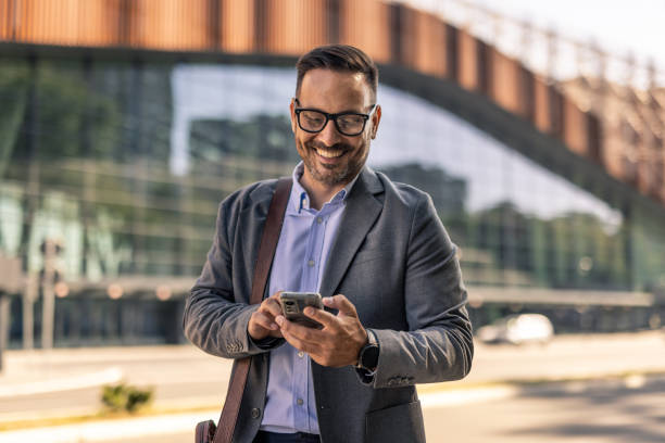 istock Businessman walking in the city, using phone 2197982637