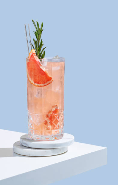 istock Refreshing mocktail with grapefruit, rosemary and ice in a glass on a blue background with shadow. 2197985364