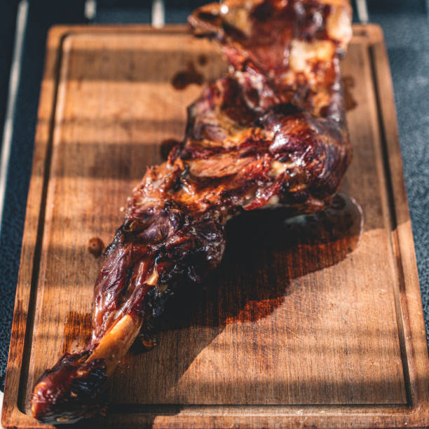 Roasted lamb leg on wooden board macrophotography